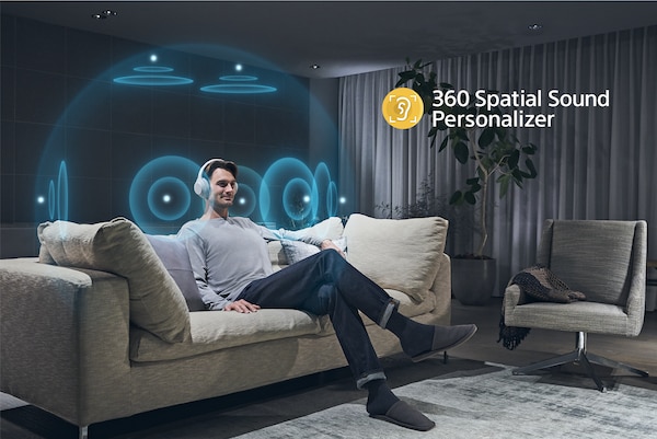 Un hombre en un sofá escuchando con los audífonos con una ilustración del efecto de 360 Spatial Sound Personalizer alrededor de su cabeza