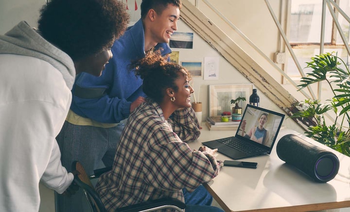 Imagen de personas junto a una laptop y el parlante inalámbrico portátil SRS-XG300 serie X